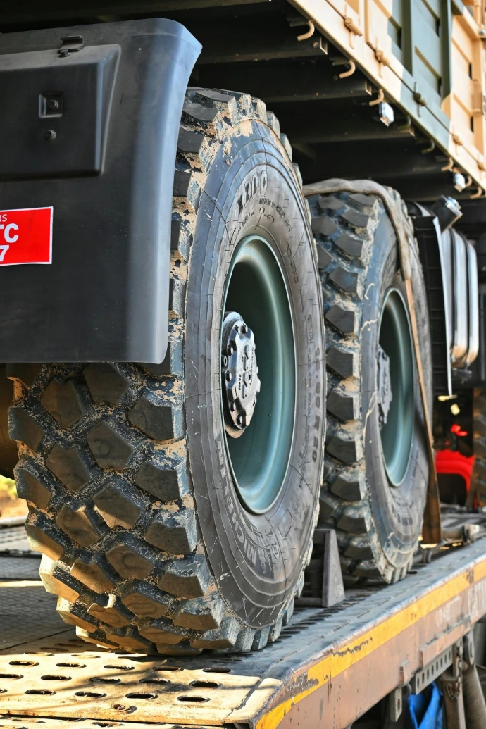 a flatbed truck with two large tires on it's flatbed